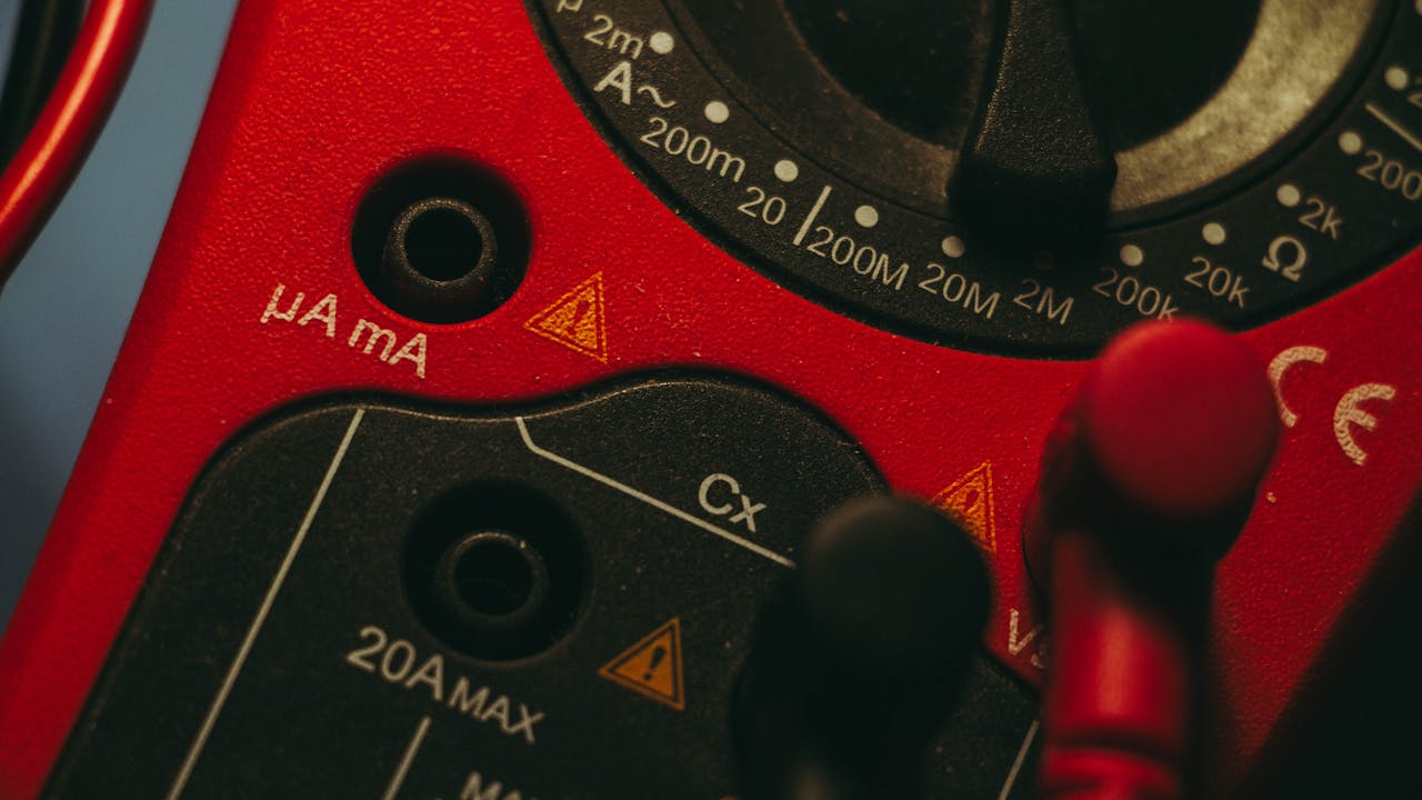 gallery-06 Detailed image of a red multimeter, showcasing measurement dial and connectors, ideal for tech enthusiasts.